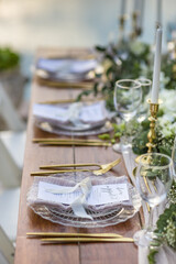 Romantic Wedding Table Top Layout Table Spread with flowers no people with gold cutlery white table cloth and scenic view of sunset and blue skies with copy space tablescape