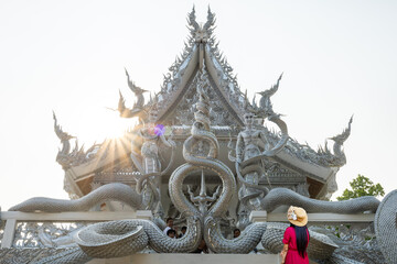 Fototapeta na wymiar Sisaket, Thailand - 6 April 2021: Art on Naga on a Thai temple pavilion. Tourists visiting Thai temples, Sisaket Province, Thailand.