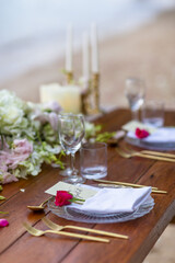 Romantic Wedding Table Top for Two 2 people Layout Table Spread no people tropical beach location with gold cutlery and scenic view of sunset on the beach soft light