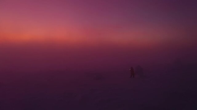 Aerial view of Santa walking in foggy winter nature, sunset in Lapland - reverse, drone shot