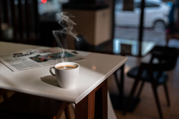 Fototapeta na wymiar White coffee mug on the table inside the cafe