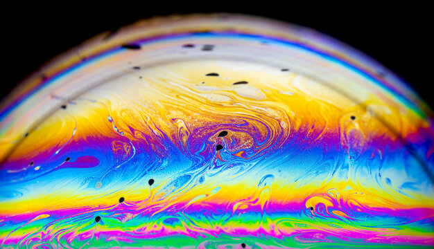 Extreme closeup up soap bubble art wave and patterns with  light effects isolated on black background.