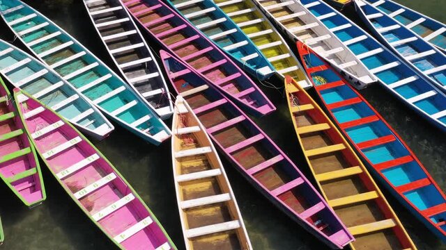 Colourful boats parking in Tamasopo River, San Luis Potosi, Mexico. Green river flowing in a mountain valley. Aerial view. Video made by drone.