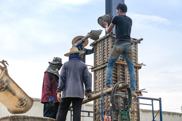 Workers cast cement columns roof structure factory.