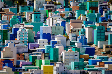 A hillside cemetery of vibrant colors Sololá Guatemala.  in Guatemala family members paint the...