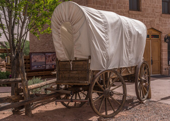 Traditional horse drawn wagon with white canvas cover used by pioneers to travel in the American...