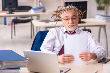 Old male employee wearing prickly wreath on head
