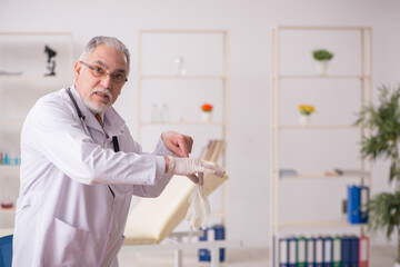 Old male doctor pharmacist working in the clinic