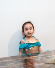 Little girl wearing Arabian costume sitting at the table.