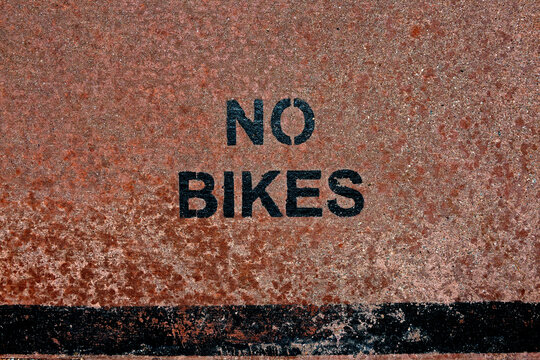 English words NO BIKES stenciled on the ground