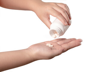 Woman hand pouring tablets from medication bottle isolated on white background.