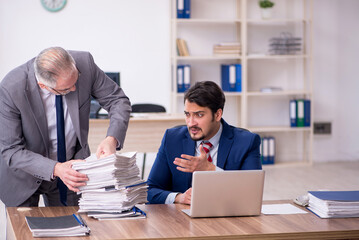 Two male employees and too much work in the office