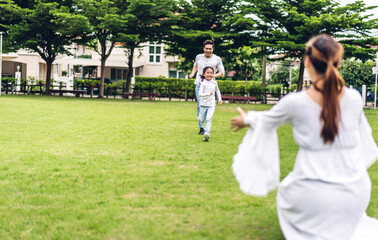 Portrait of enjoy happy love asian family father and mother with little asian girl smiling running playing and having fun moments good time in summer park at home