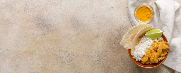 Bowl of tasty chicken tikka masala and rice on grey background with space for text
