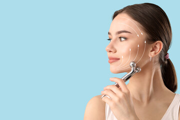 Beautiful woman massaging her face against color background