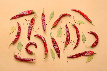 Dry hot chili peppers and spices on color background
