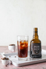Glass and bottle of cold brew coffee on table