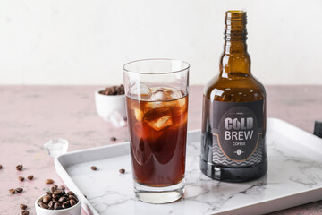 Glass and bottle of cold brew coffee on table