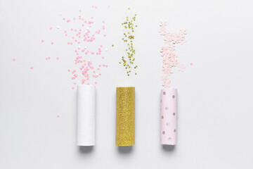 Party poppers and confetti on white background