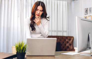 Young smiling happy beautiful asian woman relaxing using laptop computer in the room at home.Young creative girl working and typing on keyboard.work from home concept