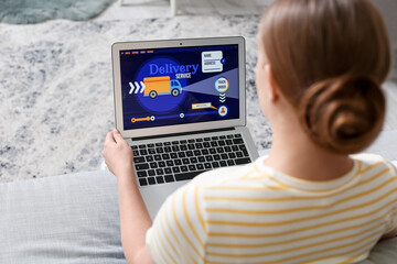 Woman using laptop with open page of delivery service application at home