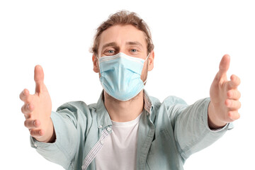 Young man in medical mask opening arms for hug on white background