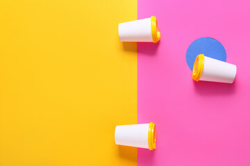 Blank paper cups on color background