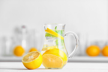Jug of tasty cold lemonade in kitchen