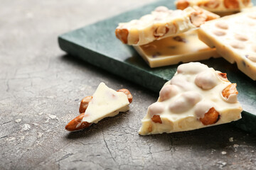 Pieces of white chocolate with nuts on grunge background