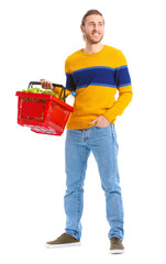 Young man with shopping basket on white background