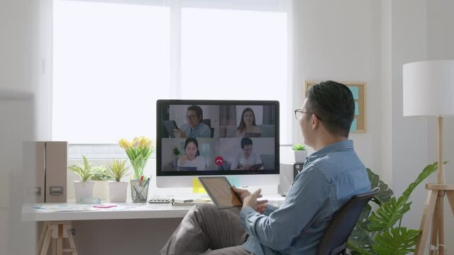 Asian business man talking about sale report in video conference.Asian team using laptop and tablet online meeting in video call.Working from home, Working remotely and Self isolation at home