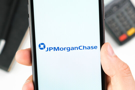 JP Morgan Chase bank logo on the smartphone screen in mans hand on the background of payment terminal, May 2021, San Francisco, USA