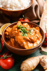 Bowl of tasty chicken tikka masala on table