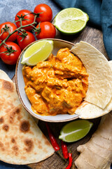 Bowl of tasty chicken tikka masala on table