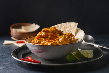 Bowl of tasty chicken tikka masala on dark background