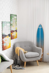 Surfboard with armchair in interior of room