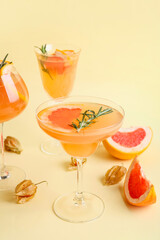 Glasses of tasty grapefruit cocktail on color background