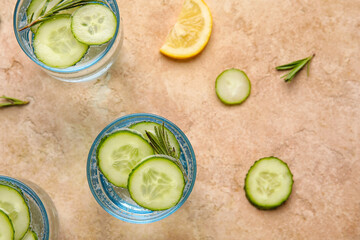 Glass with cucumber lemonade on color background