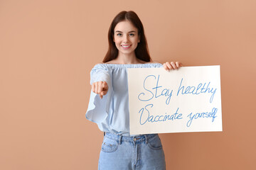 Fototapeta na wymiar Young woman holding poster with text STAY HEALTHY - VACCINATE YOURSELF on color background