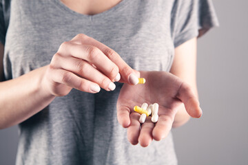 young girl holding pills in her hand