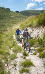Fototapeta premium Mountain bikers riding in the steep hills of Gaeta Italy on a summer day