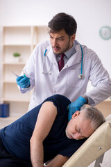 Obraz premium Old male patient visiting young male doctor in vaccination conce