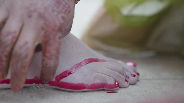 Religious mehndi applied on woman&rsquo;s leg. Woman&rsquo;s leg full of red mehndi. 