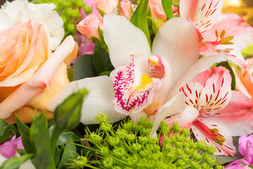 A closeup view of a floral bouquet, featuring a white boat orchid, also known as Cymbidium.
