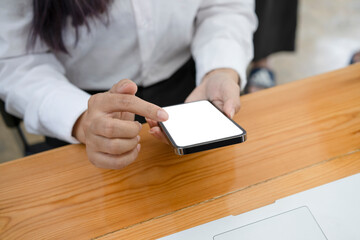 Cropped shot of female employee taking break in office and using mobile phone.