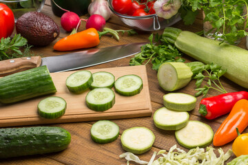 Sliced cucumbers and knife on cutting board