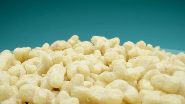 MACRO: Many star figure corn flackes on a blue dish, Dolly motion