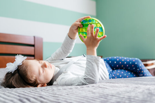 Child Playing With The Pop It Fidget. Rainbow Pop It Fidget Toy