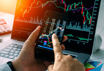 Businessman checking stock market by his smartphone and labtop.Trade and finance concept