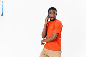 Fototapeta premium young african man with mobile phone near ear on light background cropped view